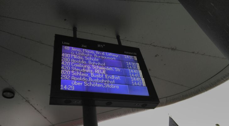 Blick auf eine digitale Anzeigetafel auf der die Abfahrzeiten verschiedener Buslinien vermerkt sind.